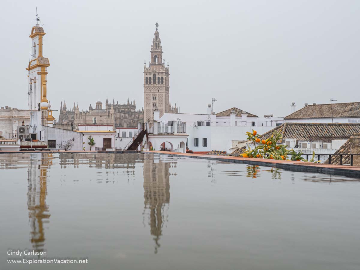 photo of towers in Seville Spain reflected in a pool on a roof deck © Cindy Carlsson at ExplorationVacation