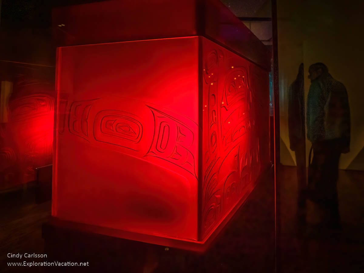 photo of a red glass box Keiwa.aa Lákt (Box with Daylight), 2018; kiln-formed and sand-carved glass; neon lighting by Tlingit artist Preston Singletary for "Raven and the Box of Daylight" at the National Museum of the American Indian Washington DC © Cindy Carlsson at ExplorationVacation.net