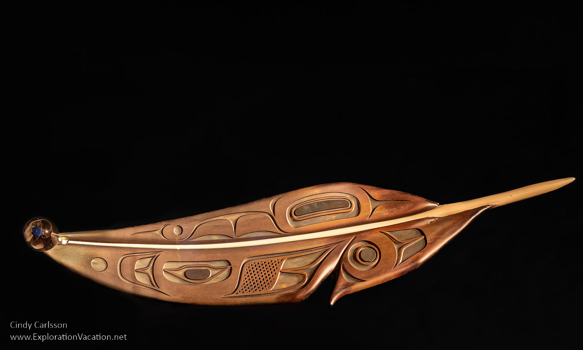 photo of a glass feather with a drop of water and speck of dirt by Tlingit artist Preston Singletary for "Raven and the Box of Daylight" at the National Museum of the American Indian Washington DC © Cindy Carlsson at ExplorationVacation.ne