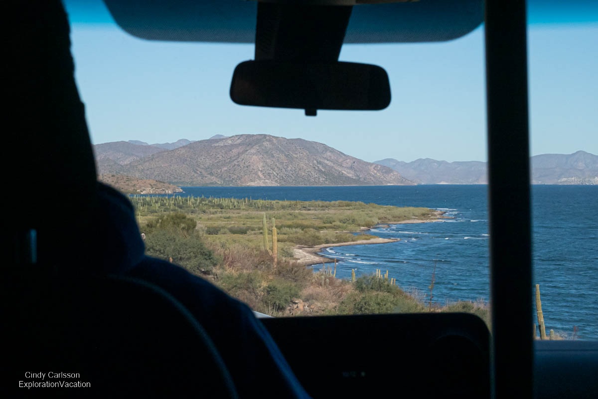 photo out the front window of a bus of the view of the coast of the Sea of Cortez (Gulf of California) north of Loreto Mexico &copy; Cindy Carlsson at ExplorationVacation.net