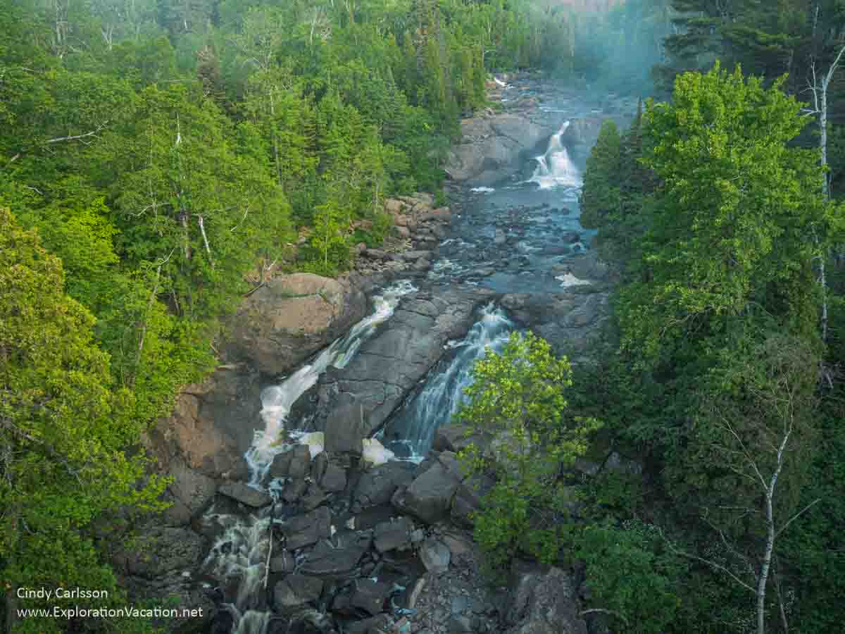 photo of the Beaver River waterfall surrounded by forest with fog rising in the background on Minnesota's North Shore &copy; Cindy Carlsson at ExplorationVacation.net 