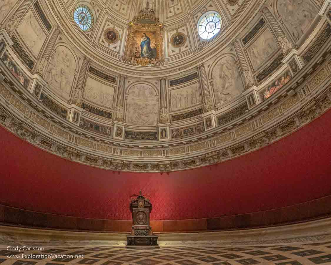 photo of the Chapter House in Seville Cathedral, which is a round room with plain red walls and an elaborate Renaissance ceiling &copy; Cindy Carlsson at ExplorationVacation.net
