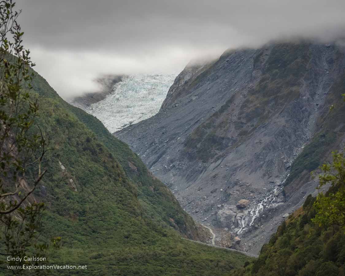 photo of Fox Glacier on a cloudy day in Westland Tai Poutini National Park, part of the Te Wāhipounamu &ndash; South West New Zealand World Heritage Site &copy; Cindy Carlsson at ExplorationVacation.net