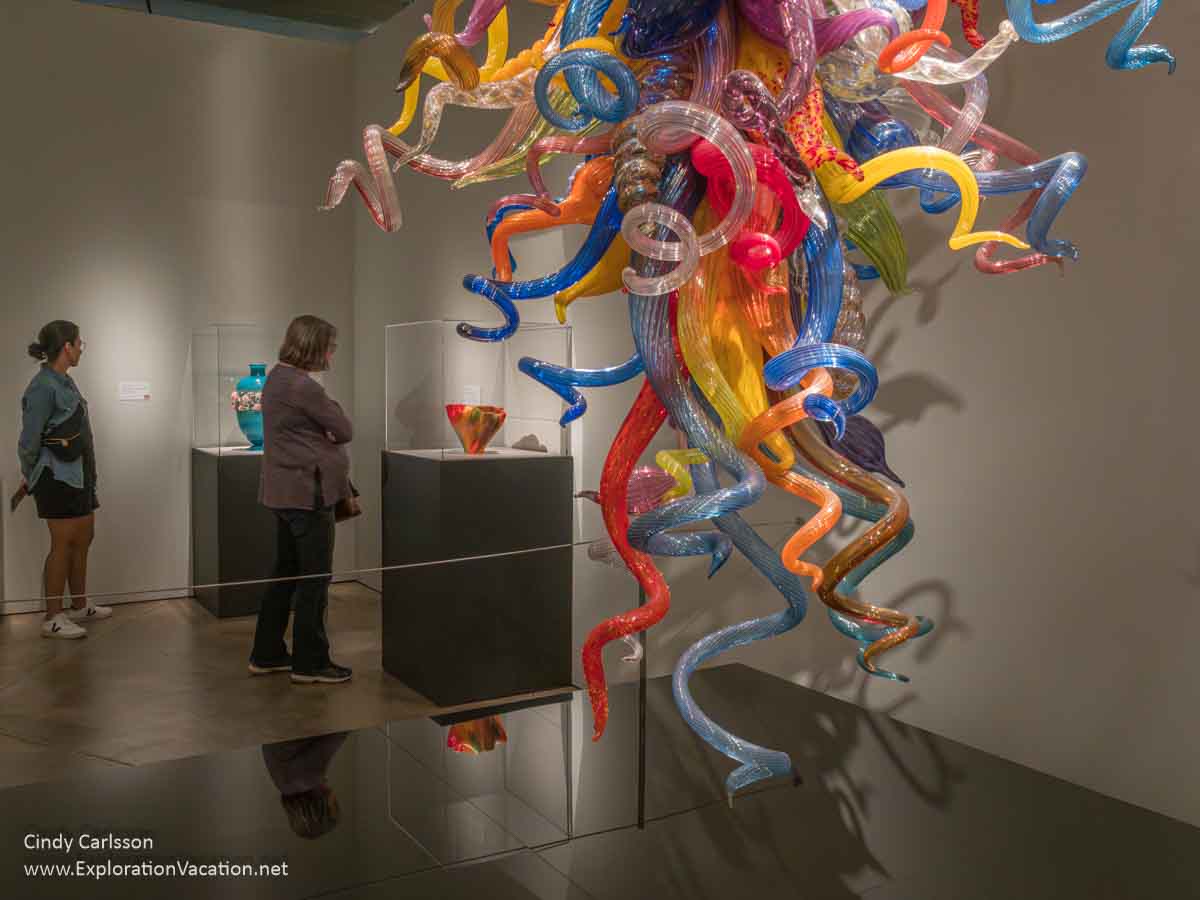 Photo of women looking at art in a gallery, including art by Dale Chihuly, Toots Zynsky, and Kari Russell-Pool at the Museum of Glass in Tacoma, Washington &copy; Cindy Carlsson at ExplorationVacation.net