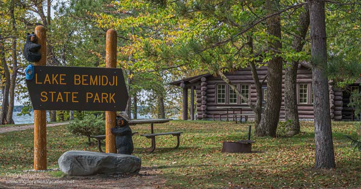 photo of sign and log cabin in Minnesota's Lake Bemidji State Park © Cindy Carlsson at ExplorationVacation.net