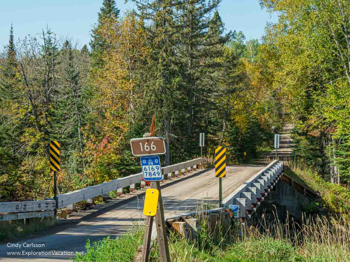 Photo of the Forest Road 166 bridge over the Temperance River, with road signs, off the Sawbill Trail in northeastern Minnesota © Cindy Carlsson at ExplorationVacation.net