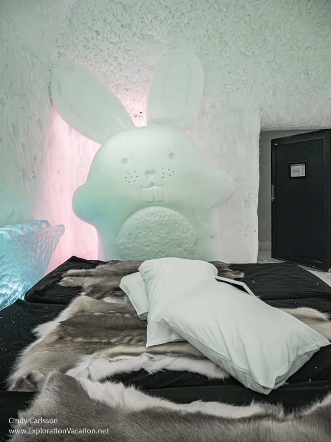 Photo of a giant rabbit looking over a bed in the Toybox suite in Icehotel 365 in Jukkasj&auml;rvi, Swedish S&aacute;pmi (Lapland) &copy; Cindy Carlsson ExplorationVacation.net