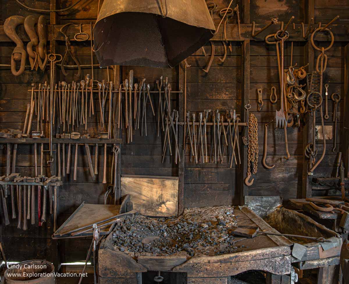 Photo of an old forge with many, many blacksmithing tools hanging from the wall in the Bally Blacksmith Shop in Grand Marais, Minnesota &copy; Cindy Carlsson at ExplorationVacation.net