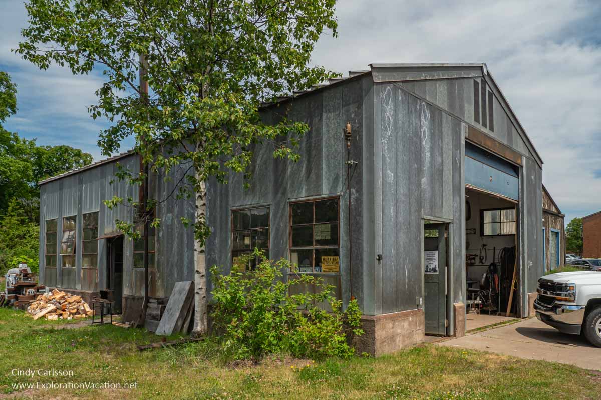 Photo of a large old building with windows and a garage door at the Bally Blacksmith Shop in Grand Marais, Minnesota &copy; Cindy Carlsson at ExplorationVacation.net