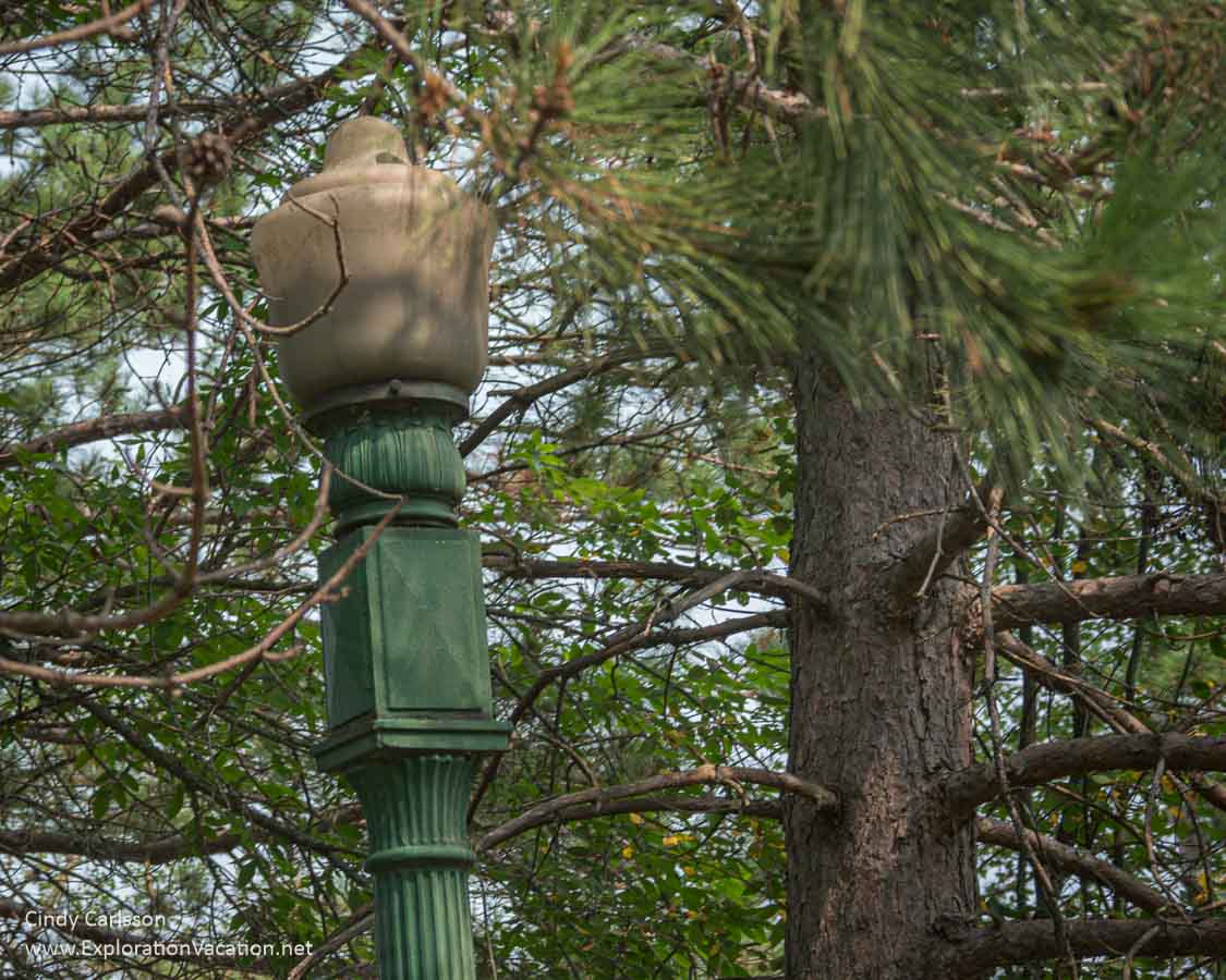 Photo of a broken street lamp amid trees at the former Hill Annex Mine State Park in Calumet, Minnesota. (Photo © Cindy Carlsson at ExplorationVacation.net)