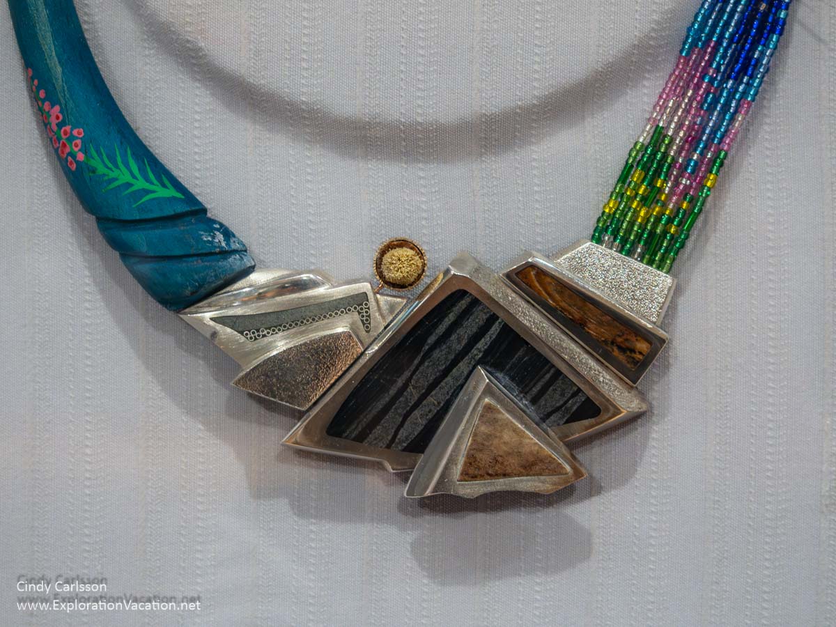Photo of an art necklace by Donald Stuart created to honor Kwanlin Dün First Nation Elder Judy Gingell on display in 2018 as part of the “Homage: Inspired by Outstanding Canadian Women” exhibit at the Dennos Museum Center at Northwestern Michigan College in Traverse City, Michigan. (Photo © Cindy Carlsson on ExplorationVacation.net)