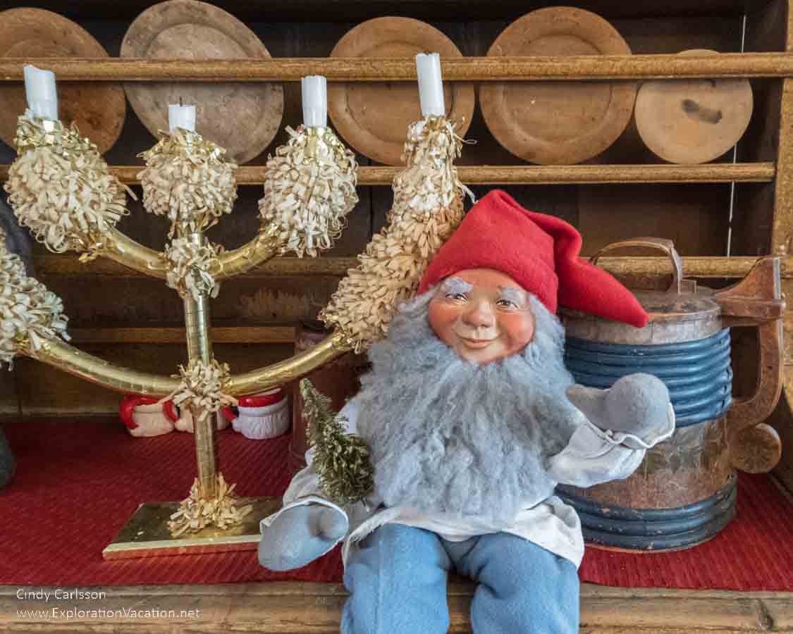 Photo of an elf holding a toy Christmas tree at the Tyynel&auml; Elf Village (Tyynel&auml;n Tonttukyl&auml;) in Larsmo, Finland. (Photos &copy; Cindy Carlsson at ExplorationVacation.net)
