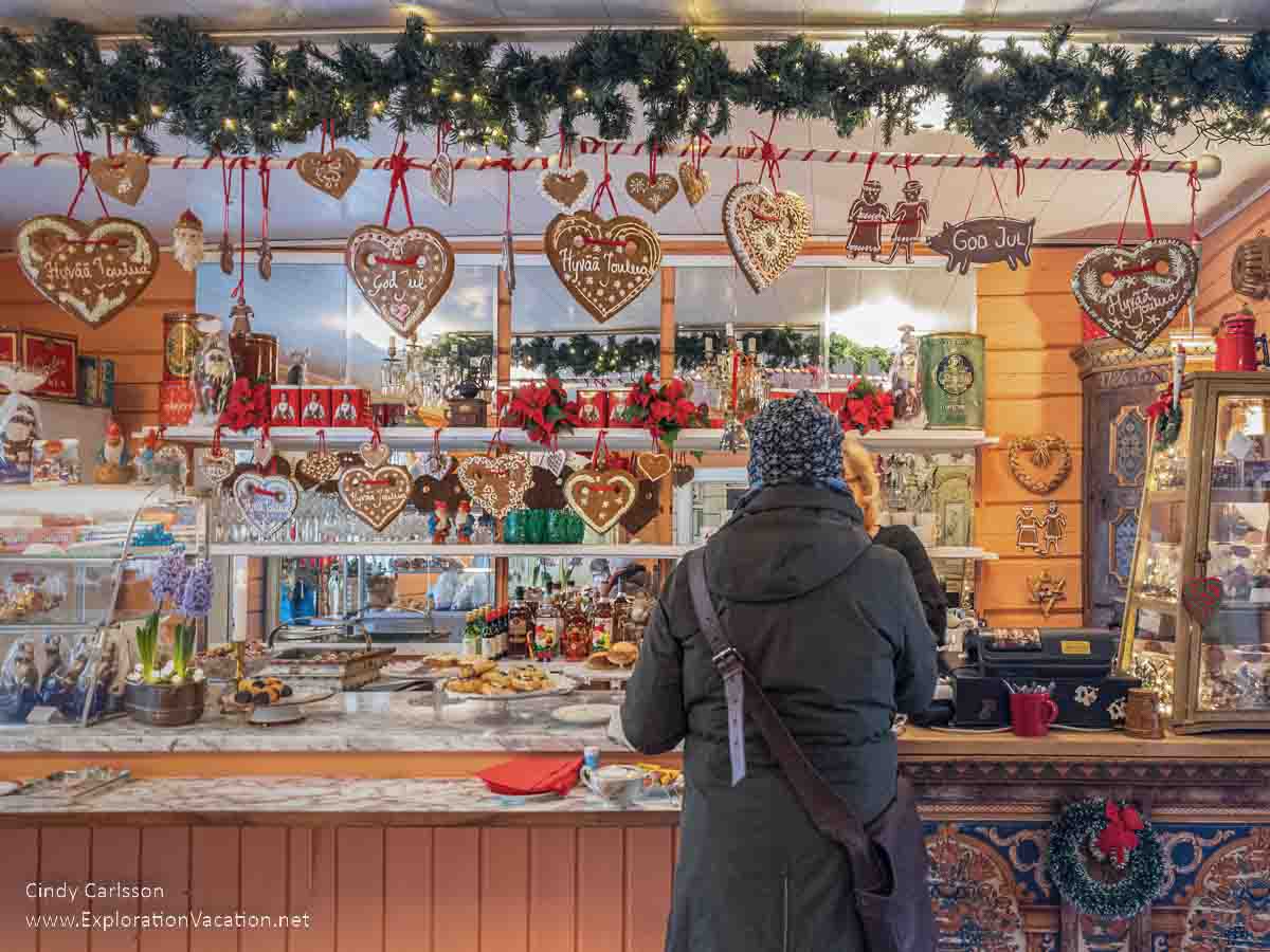 Photo of a woman standing at the bakery counter with gingerbread cookies hung like decorations at the Tyynel&auml; Elf Village (Tyynel&auml;n Tonttukyl&auml;) in Larsmo, Finland. (Photos &copy; Cindy Carlsson at ExplorationVacation.net)