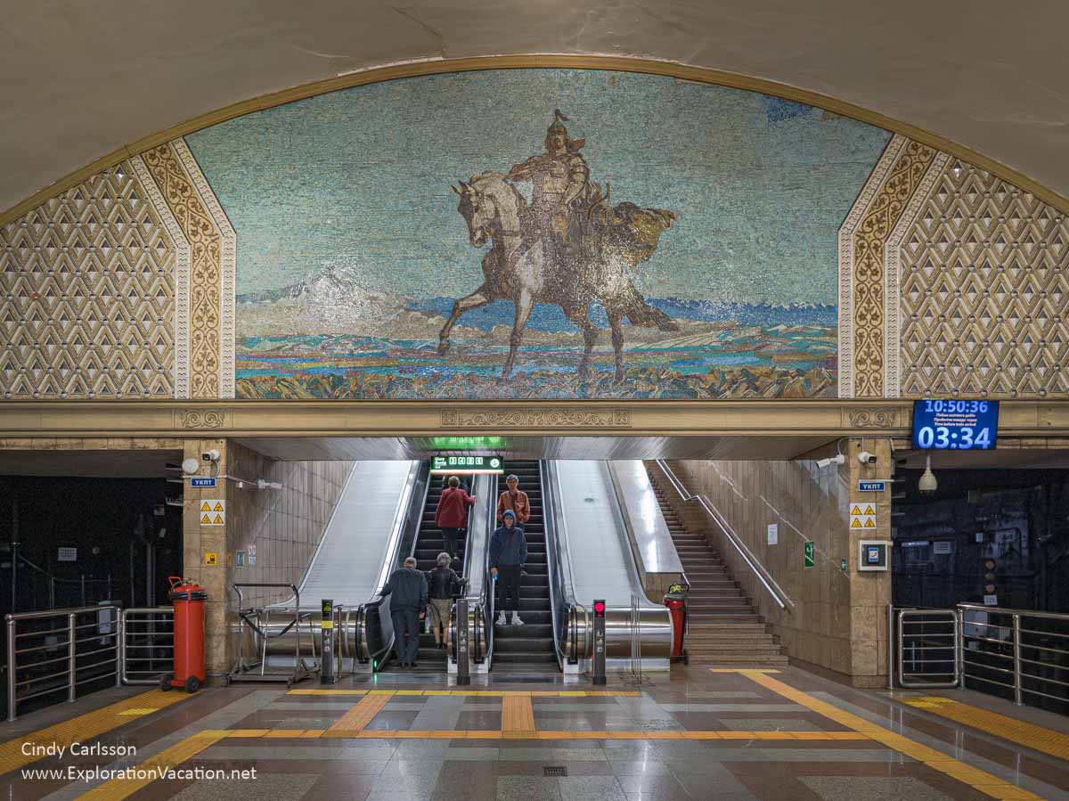 A large mural of Kazakh hero Raiymbek Batyr above the escalators in an Almaty Metro station.