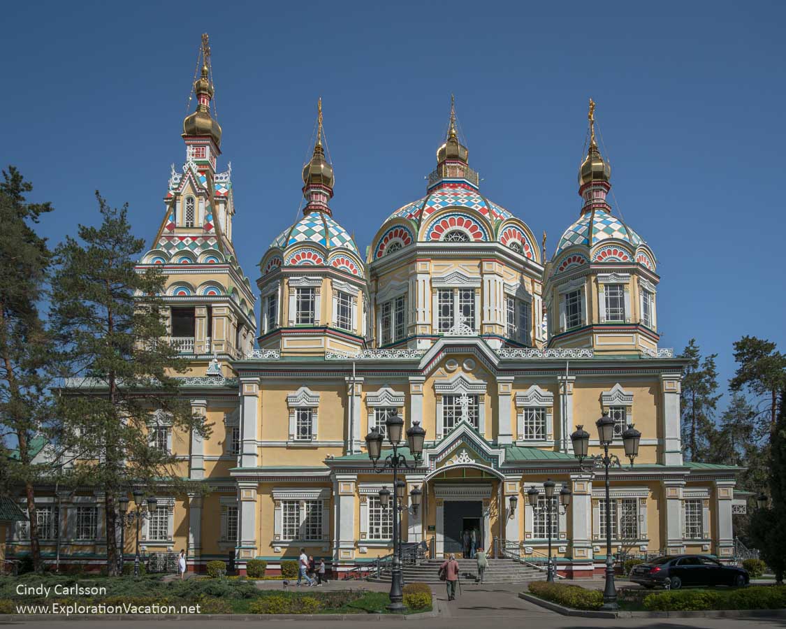 A large, colorful wooden Russian Orthodox church with multiple domes. 