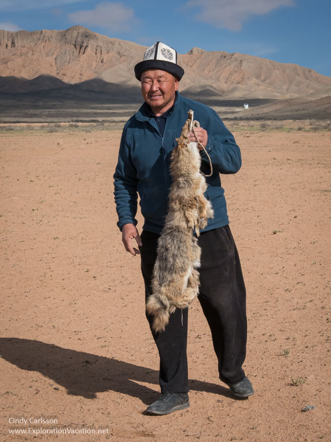 A Kyrgyz man holding a fox pelt.