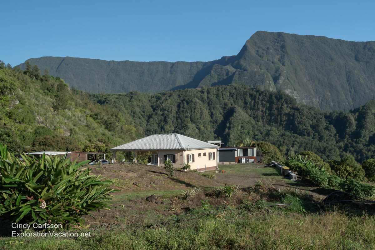 A simple house surrounded by mountains.