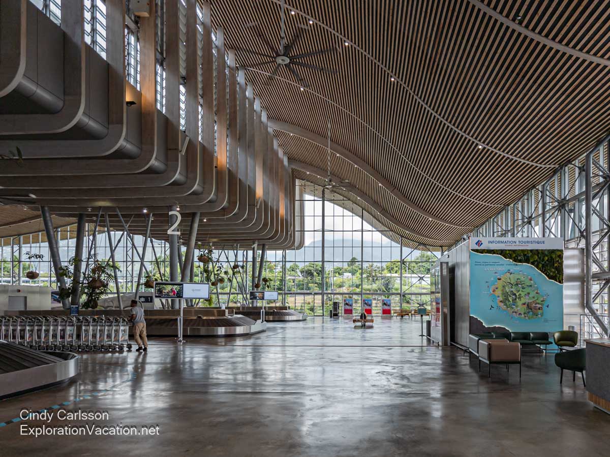 The airport baggage area, with a swooping wood ceiling and a wall of windows with a view to the mountains.