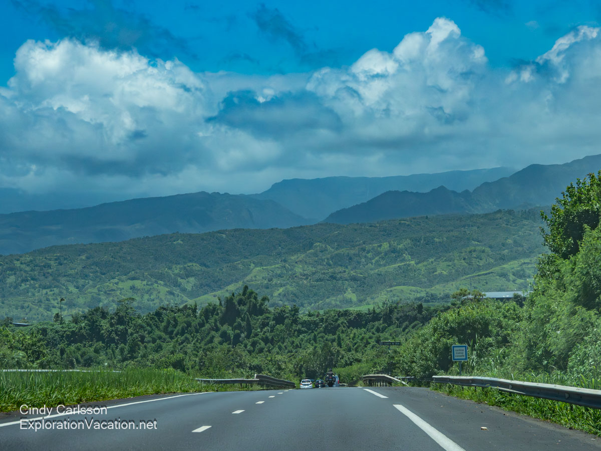Forested mountains in the distance, as seen from a highway.