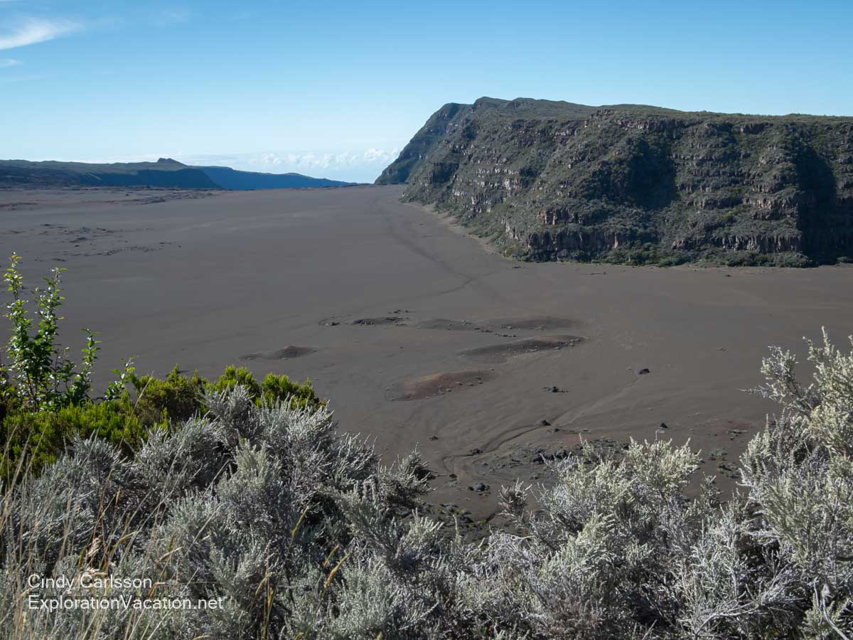 A barren volcanic plain and crater walls.