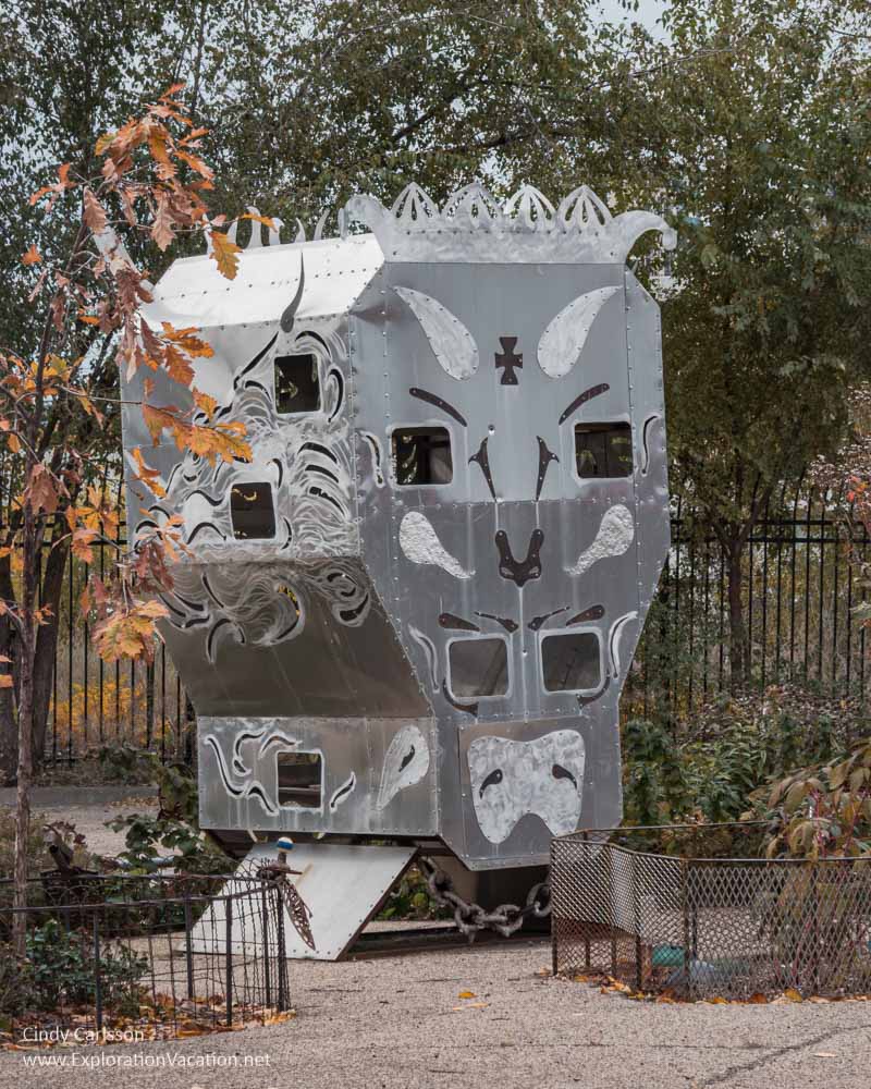 A giant metal bin or chute transformed into a rather monstrous face with windows.