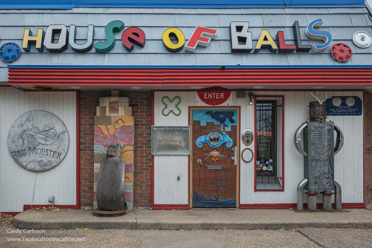 The building entrance with large letters spelling out the "House of Balls" and a variety of metal sculptures and other art.